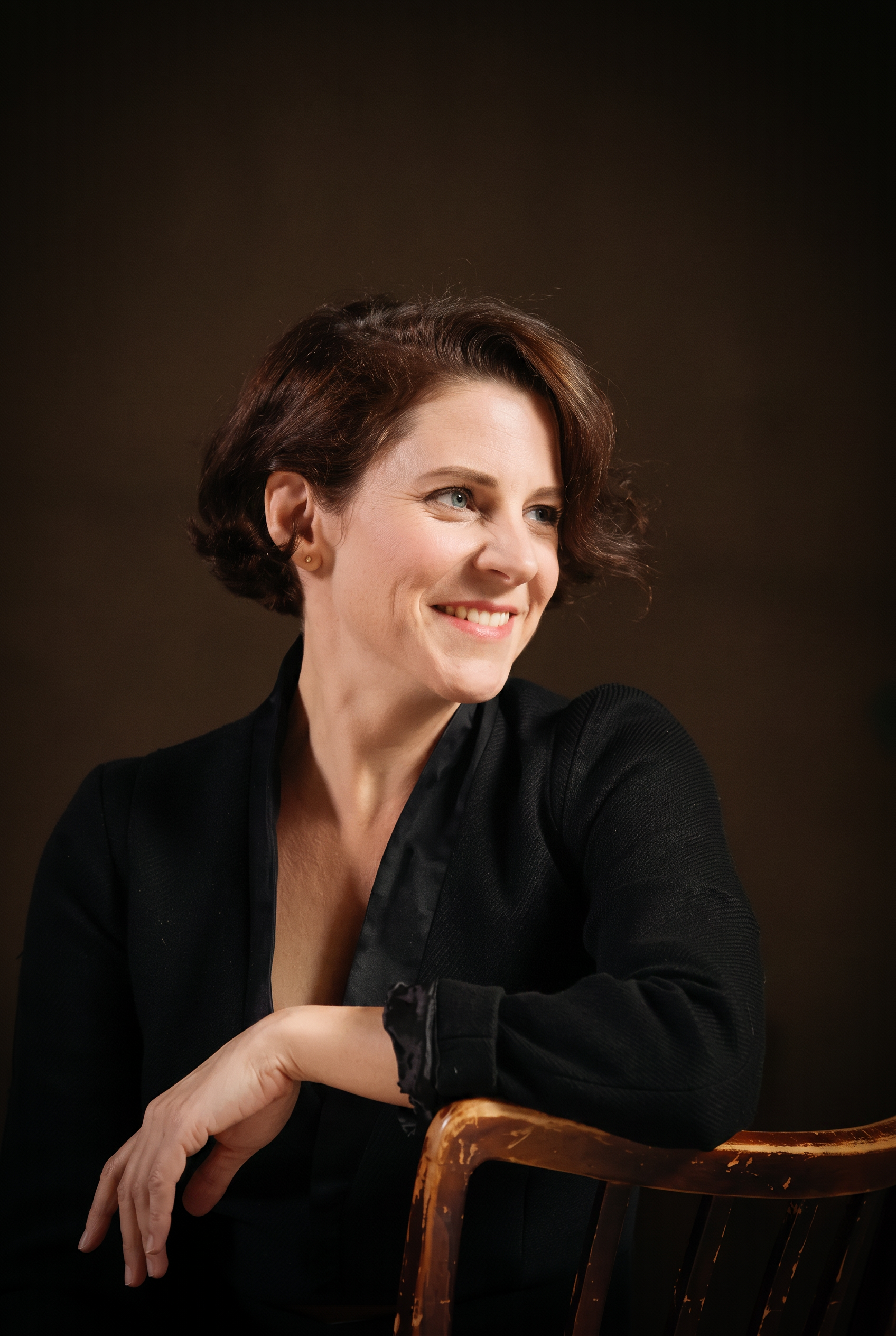 Portrait of Teresa Zimmermann, smiling warmly against a dark studio background